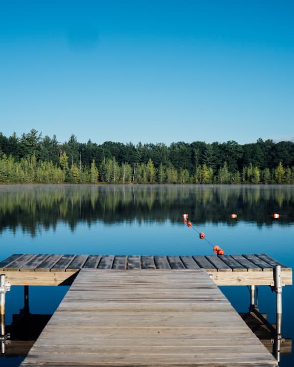 Calm mountain lake reflecting snow-capped peaks at dawn