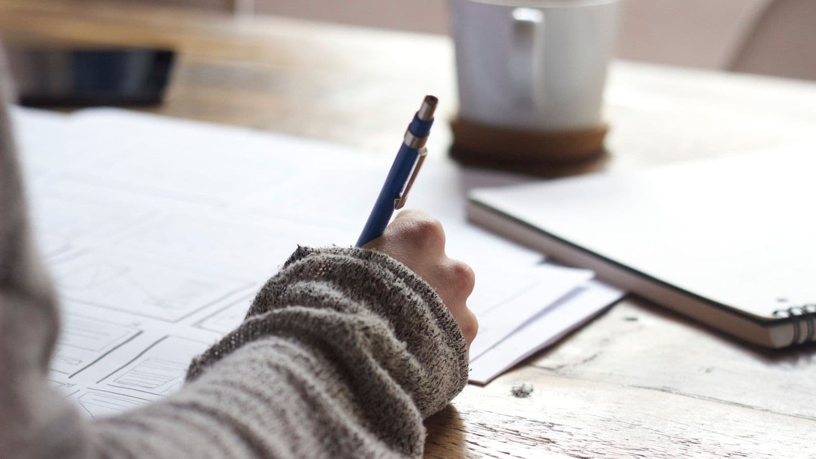Notebook with charts and coffee on a workspace