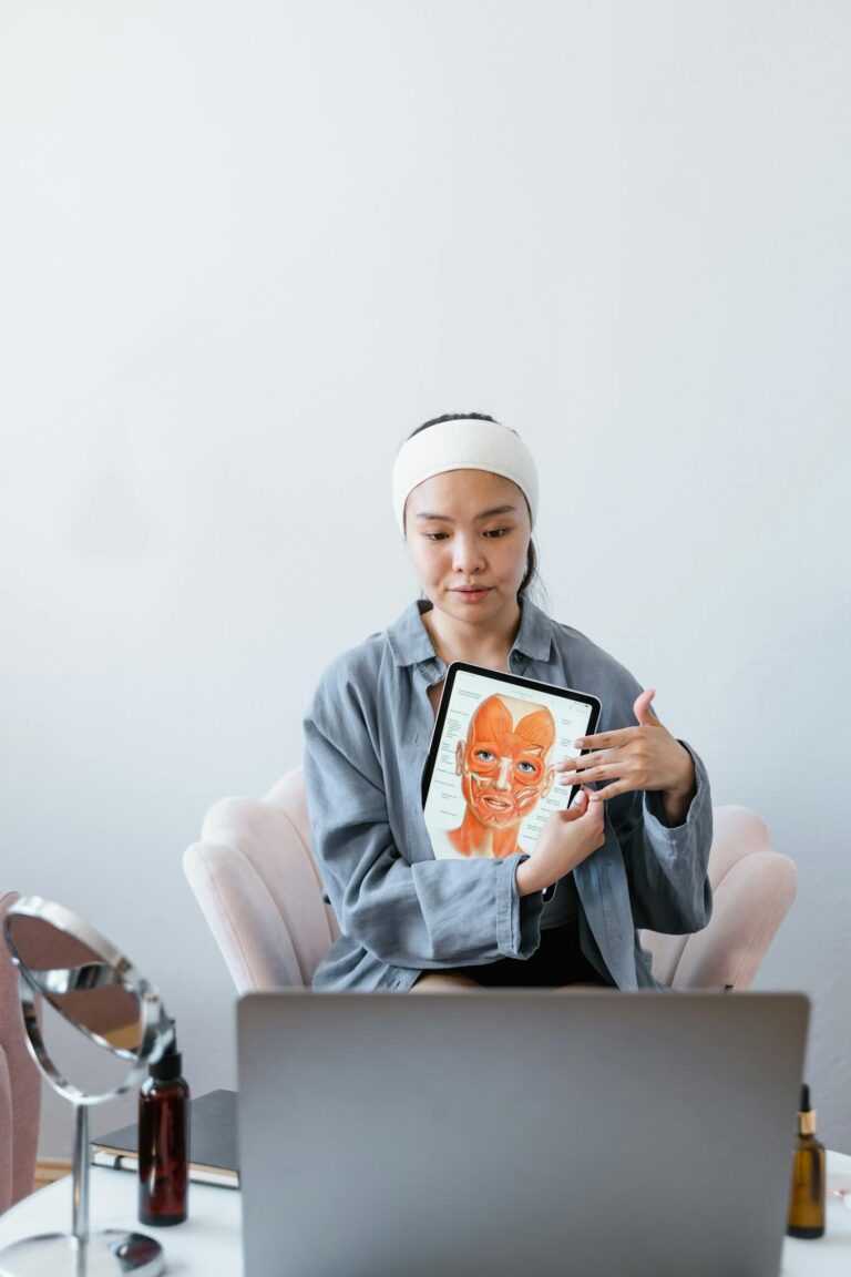 Woman presents skincare procedure technique using tablet in a home setting.